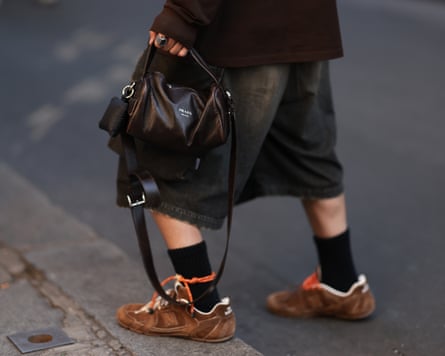 Street Style - Paris Fashion Week - Menswear Spring/Summer 2026 - Day OnePARIS, FRANCE - JUNE 24: Ryo Takashima is seen wearing a dark brown long-sleeved polo shirt from Miu Miu; wide-leg dark grey capri jeans; a rectangular black leather bag from Prada; a chunky silver ring; black socks; and brown suede sneakers with brown soles and two different shoelaces in orange cotton and brown leather from Miu Miu x New Balance during the Auralee Menswear Spring/Summer 2026 show as part of Paris Fashion Week on June 24, 2025 in Paris, France. (Photo by Jeremy Moeller/Getty Images)