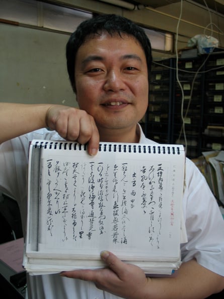 Prof Yasuyuki Aono holding a printout of Japanese handwritten script