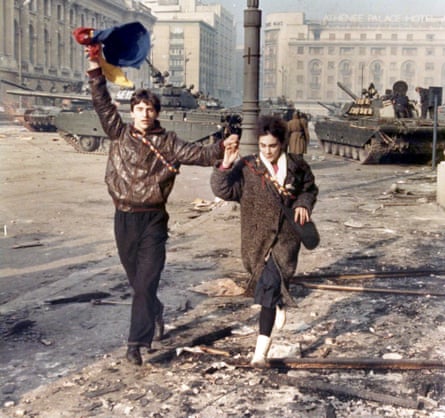 A couple run for cover during a battle between armed civilians and pro-Ceaușescu supporters in Bucharest, 24 December 1989.