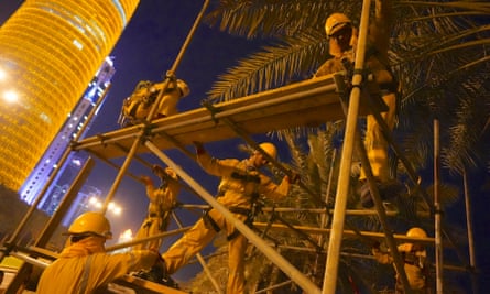 Labourers from Nepal put up scaffolding for the launch of the World Cup logo. They start work long before sunrise to avoid the heat.