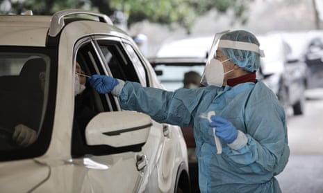 Medical worker collects a swab sample at a drive-through Covid testing centre in Mestre, Italy.