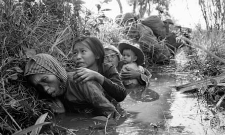 Women and children crouch in a muddy canal as they take cover from intense Viet Cong fire at Bao Trai, about 20 miles west of Saigon, Vietnam.