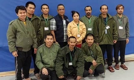 A Thai official stands with the ten Thai citizens released by Hamas.