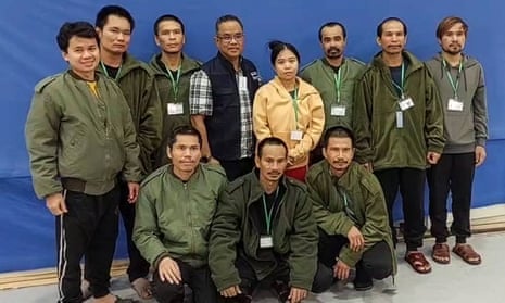 The 10 Thai hostages freed by Hamas, pictured with a Thai official in an undisclosed location