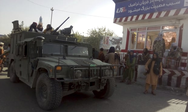 Taliban fighters stand guard at a checkpoint in Kunduz, northern Afghanistan