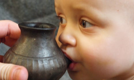A reconstruction of a baby being fed using a vessel