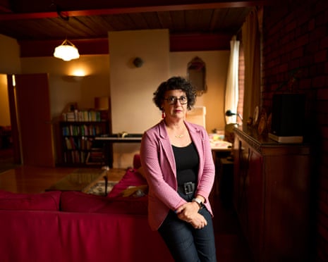 Laura Murphy leans on a sofa looking at the camera