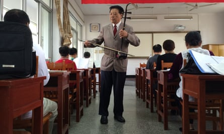 Ge Fangping, a 72-year-old music teacher, leads a class with his erhu, a Chinese fiddle.