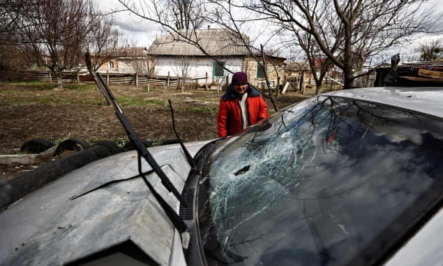 Zinaida Makishaiva, 82, looks at bullet holes in the windscreen of her son’s car parked near her house in Borodianka.