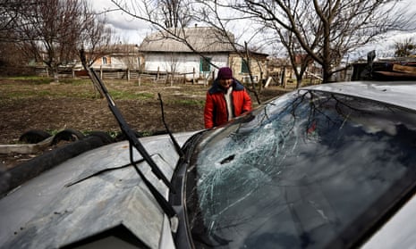 Zinaida Makishaiva, 82, looks at bullet holes in the windscreen of her son’s car parked near her house in Borodianka.