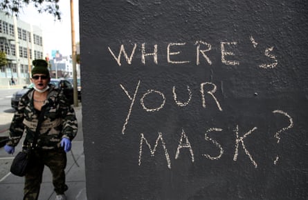 A San Francisco pedestrian passes graffiti encouraging masks during the coronavirus outbreak.