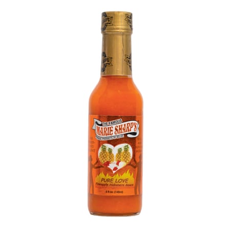 Bottle of orange-coloured sauce with pineapples on label