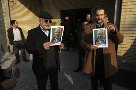 Supporters hold posters of Mohammad Baqer Qalibaf at a campaign meeting in Tehran