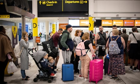 Travellers queue at Gatwick airport in London.