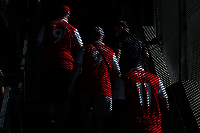 Arsenal fans make their way into the Emirates on a sunny day in North London.