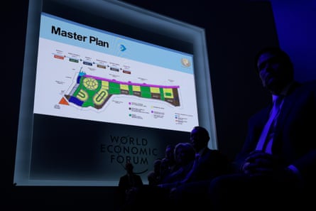 A screen showing a graphic titled ‘master plan’ in an otherwise darkened room