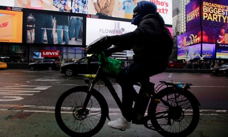 A man rides an ebike through Times Square in New York City.
