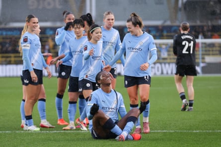 Khadija Shaw sits down in celebration after scoring against Aston Villa