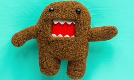 Domo Kun, brown stuffed Japanese toy with angry mouth, against turquoise background