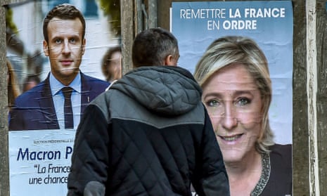 A man looking at campaign posters of French presidential election candidates