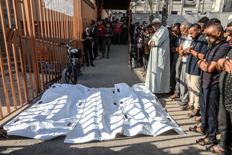 Relatives of Palestinian people, who were reportedly killed by Israeli soldiers' gunfire while waiting for American aid in Rafah, perform funeral prayers as the bodies are brought to Nasser hospital in southern Gaza.