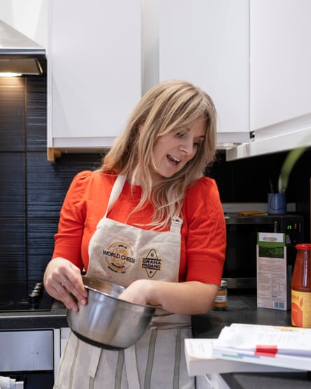 Elle with her hand in a mixing bowl, and reading a recipe.