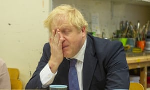 Boris Johnson holds his hand to his face