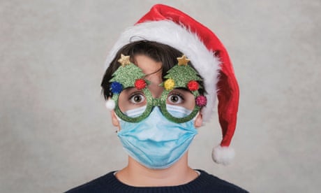 Child with mask in Christmas hat and glasses