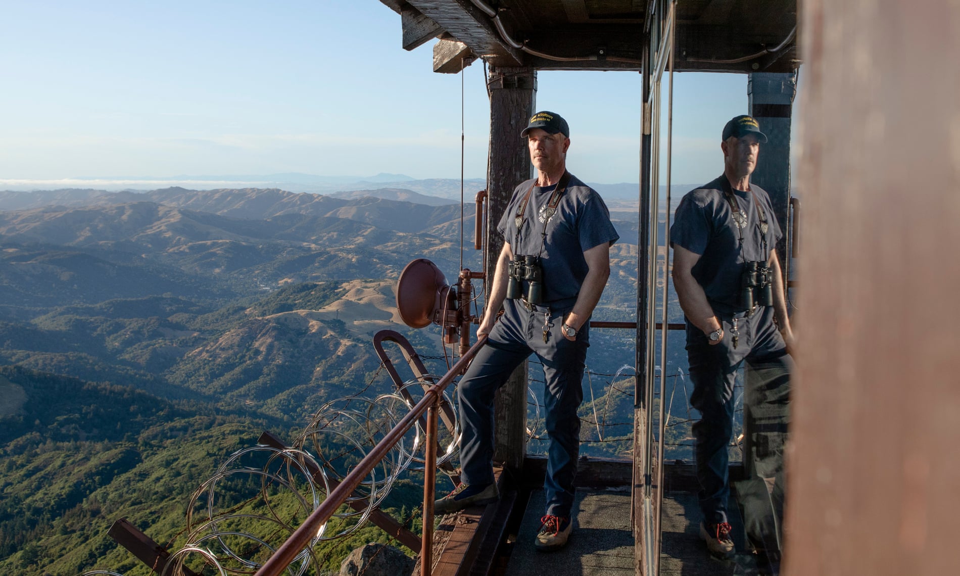 Rory Hewitt stands on the edge of a tower on Mt Tamalpais, California, where he is a volunteer lookout for wildfire ignitions. 