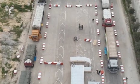 Humanitarian aid trucks wait in line to be inspected at the Kerem Shalom crossing, in this still image taken from video released on 12 December 2023