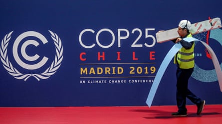A worker walks past a COP25 logo at the IFEMA Convention Centre in Madrid.