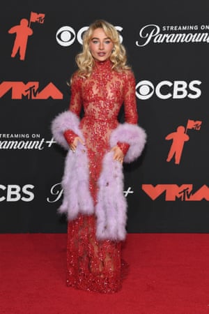 Sabrina Carpenter wears old Hollywood camp well in red Valentino gown and lavender stole.