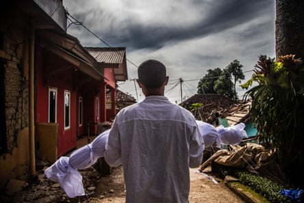A father carries his son to be buried after the Cianjur earthquake, Indonesia