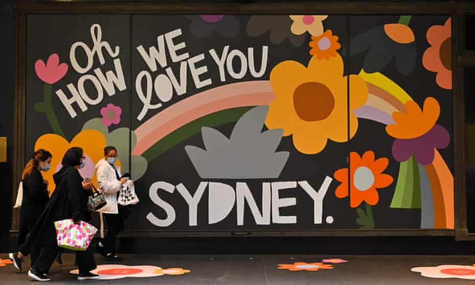People walk past a retail store in Sydney on 11 October  2021, as the city ended its 106-day Covid-19 lockdown.