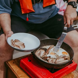 Chef Charlie Hodson prepares cooked breakfast on board the Salford whelk boat, Norfolk, UK.