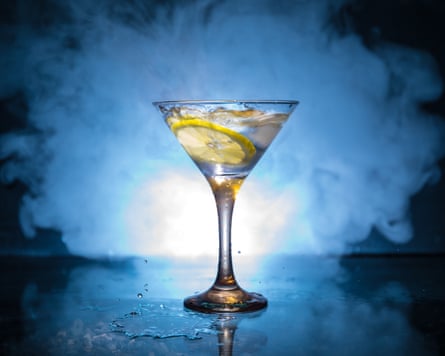 Martini cocktail glass against a dark-toned smoky blue and white background.