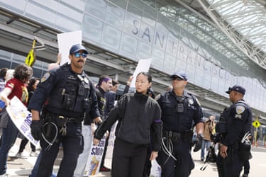 police officers and civilians stand in an airport