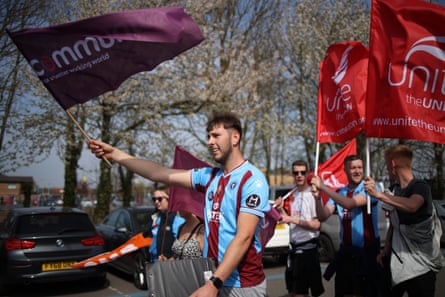 Steelworkers and members of Unite union march and wave flags