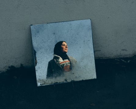 a woman’s image is reflected in a mirror