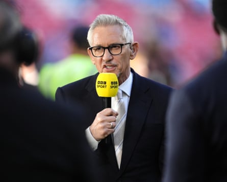 Gary Lineker in a jacket and tie speaking into a yellow BBC Sport microphone
