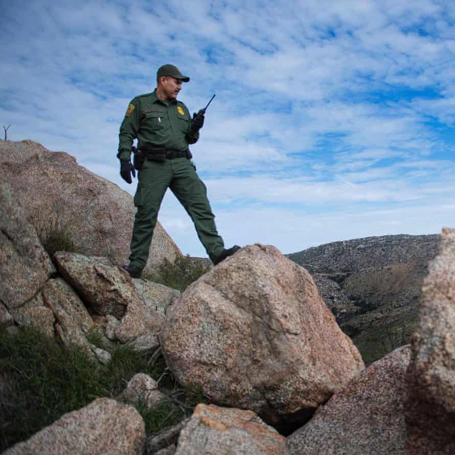 Border patrol agent Barona checks out the area after receiving a call of seismic activity on a trail in Tecate, California