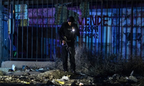 A police officer investigates a crime scene in eastern Tijuana, Mexico.