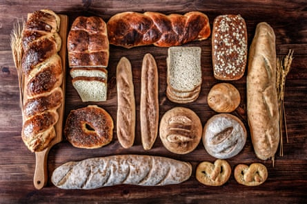 A selection of fresh bread loaves and rolls laid out of a wooden table