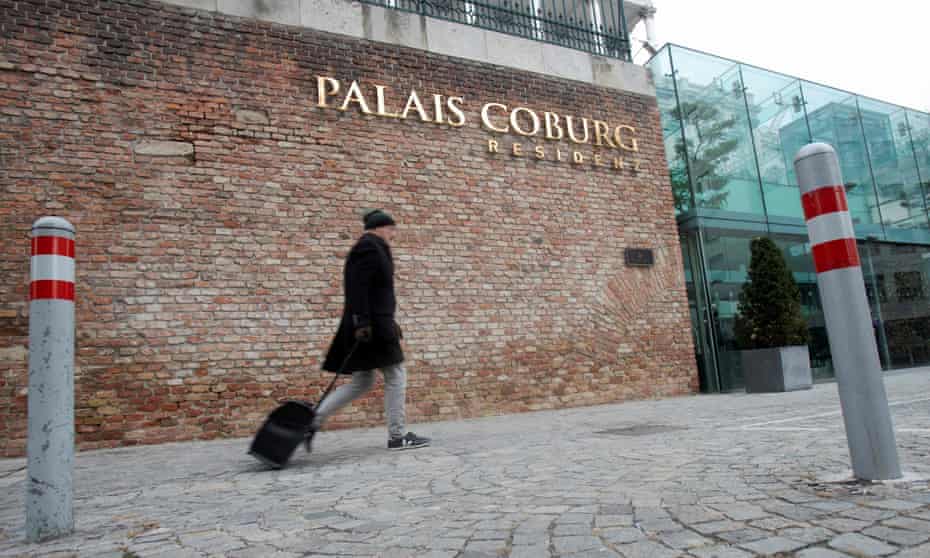 A man walks past barriers in front of the Palais Coburg hotel in Vienna