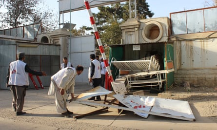 Afghan employees of the hospital move a damaged gate