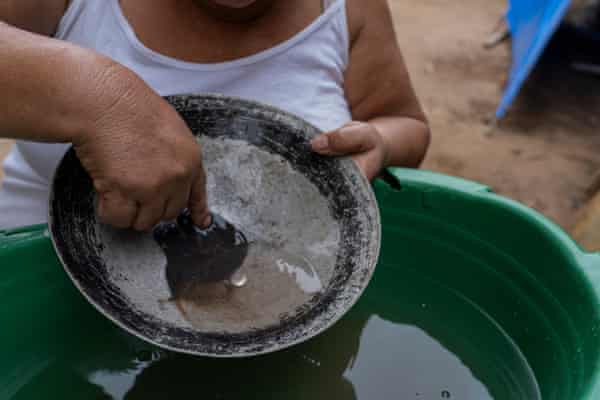 Un buscador de oro mezcla mercurio líquido con sedimentos de río en una cacerola