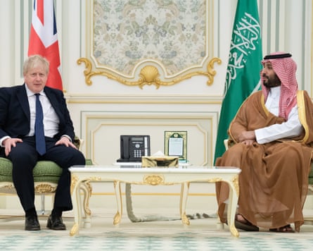 Boris Johnson and Mohammed bin Salman sitting in front of their national flags