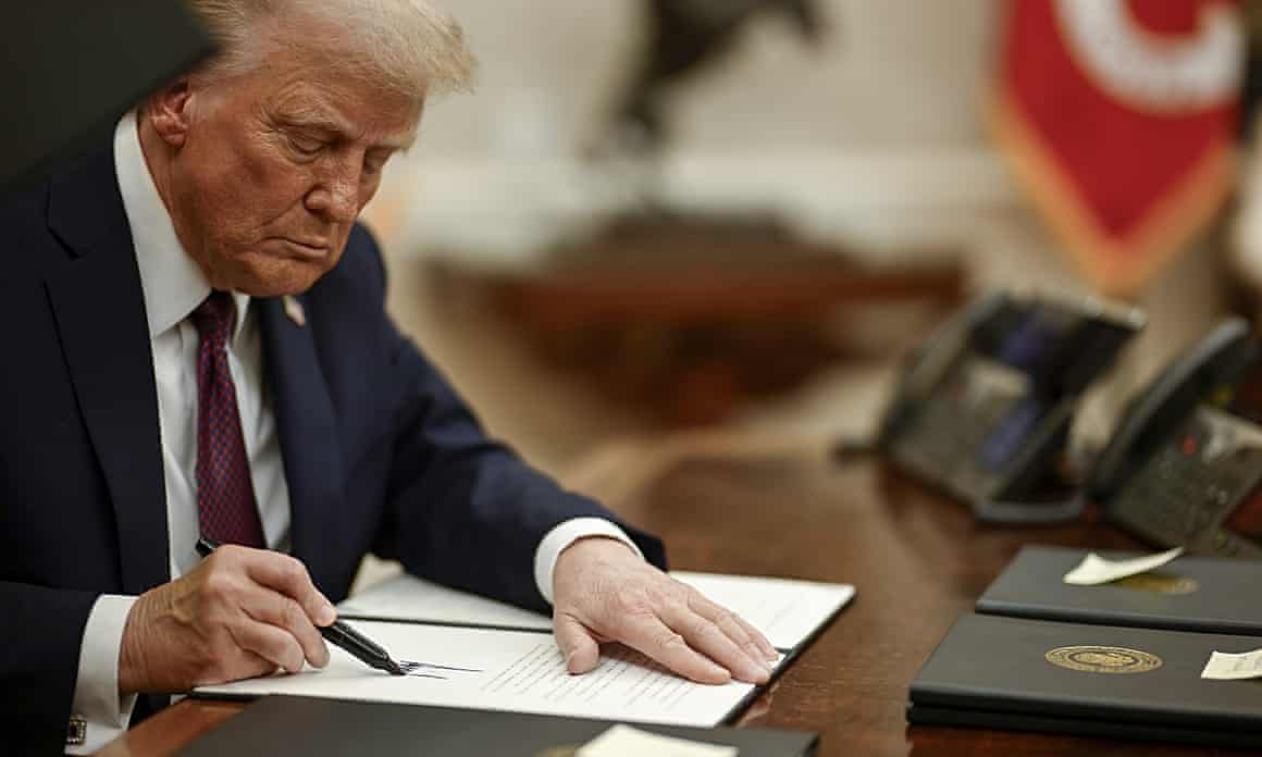 Donald Trump holding pen at desk