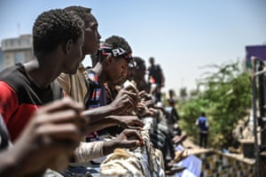 Protesters hit the rails of a bridge with stones during a protest near the military headquarters in the capital of Sudan