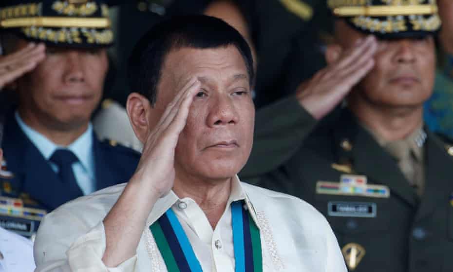 Philippine president Rodrigo Duterte salutes with other military officers during a anniversary celebration of the Armed Forces.